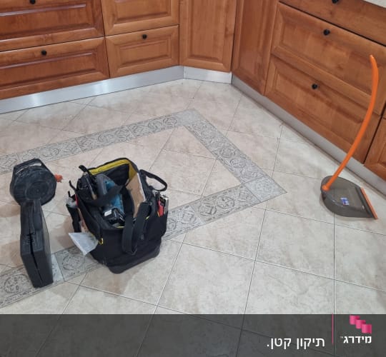 כלי עבודה ותיק כלים במטבח עם ארונות עץ